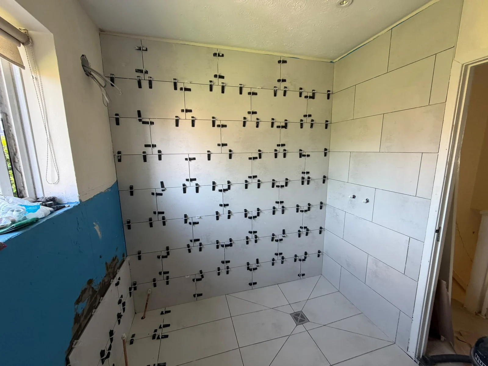 Large-format wall tiling with levelling clips in a wet room, RV Renovation, Oxford