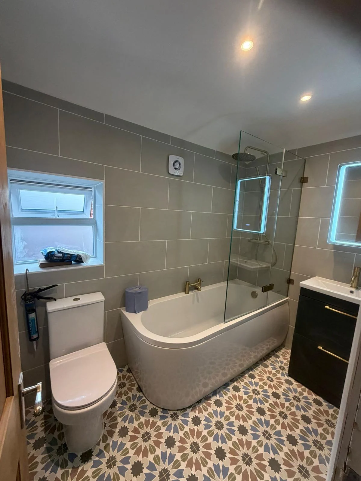 Curved bath, vanity and patterned bathroom floor — RV Renovation, Oxford