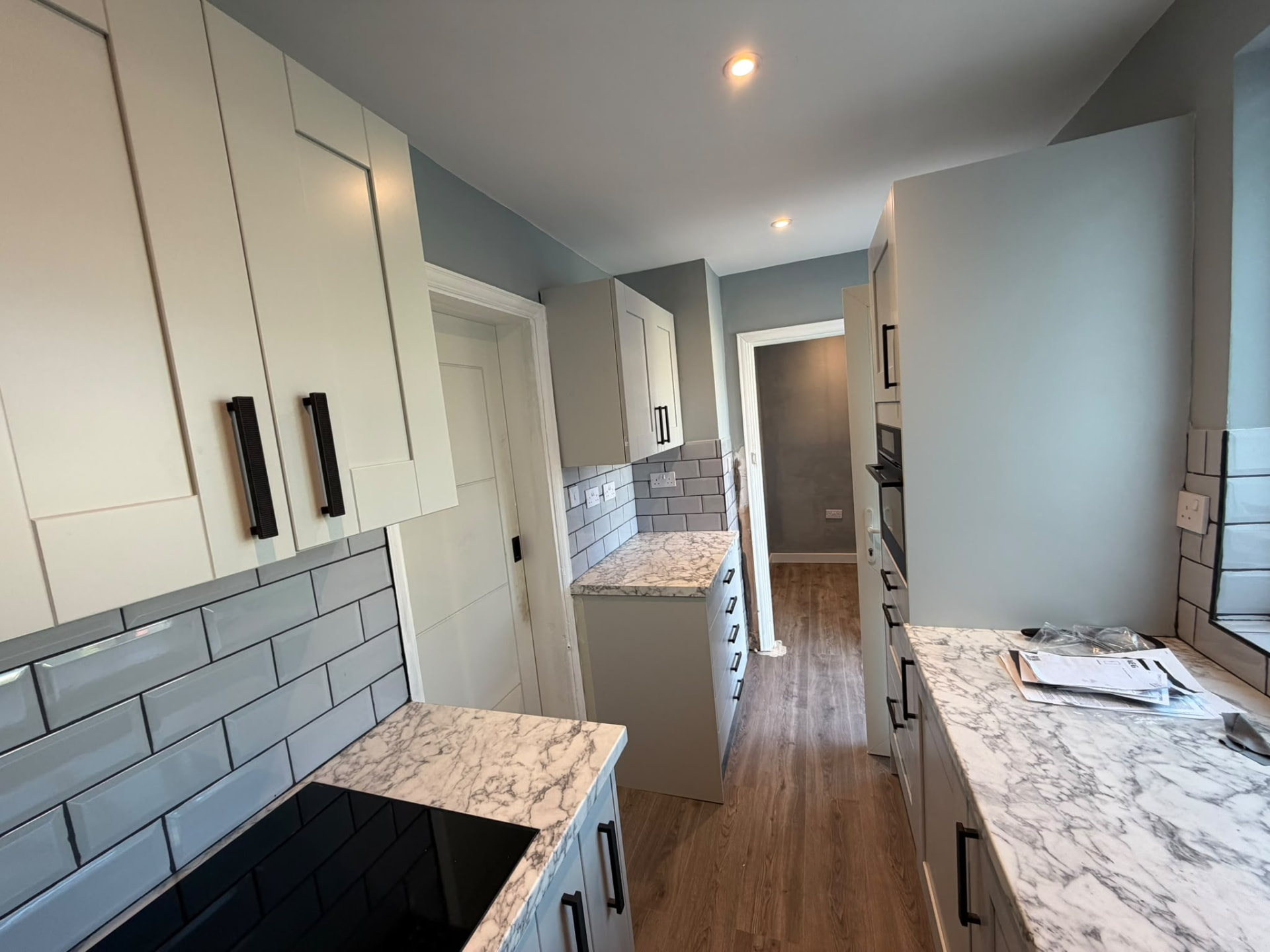 Finished kitchen with white shaker units, grey metro tiles and marble-effect worktops, RV Renovation, Oxford